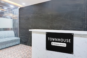 Eine Rezeption mit einem Schild, das 'TOWNHOUSE Company Serviced' zeigt.