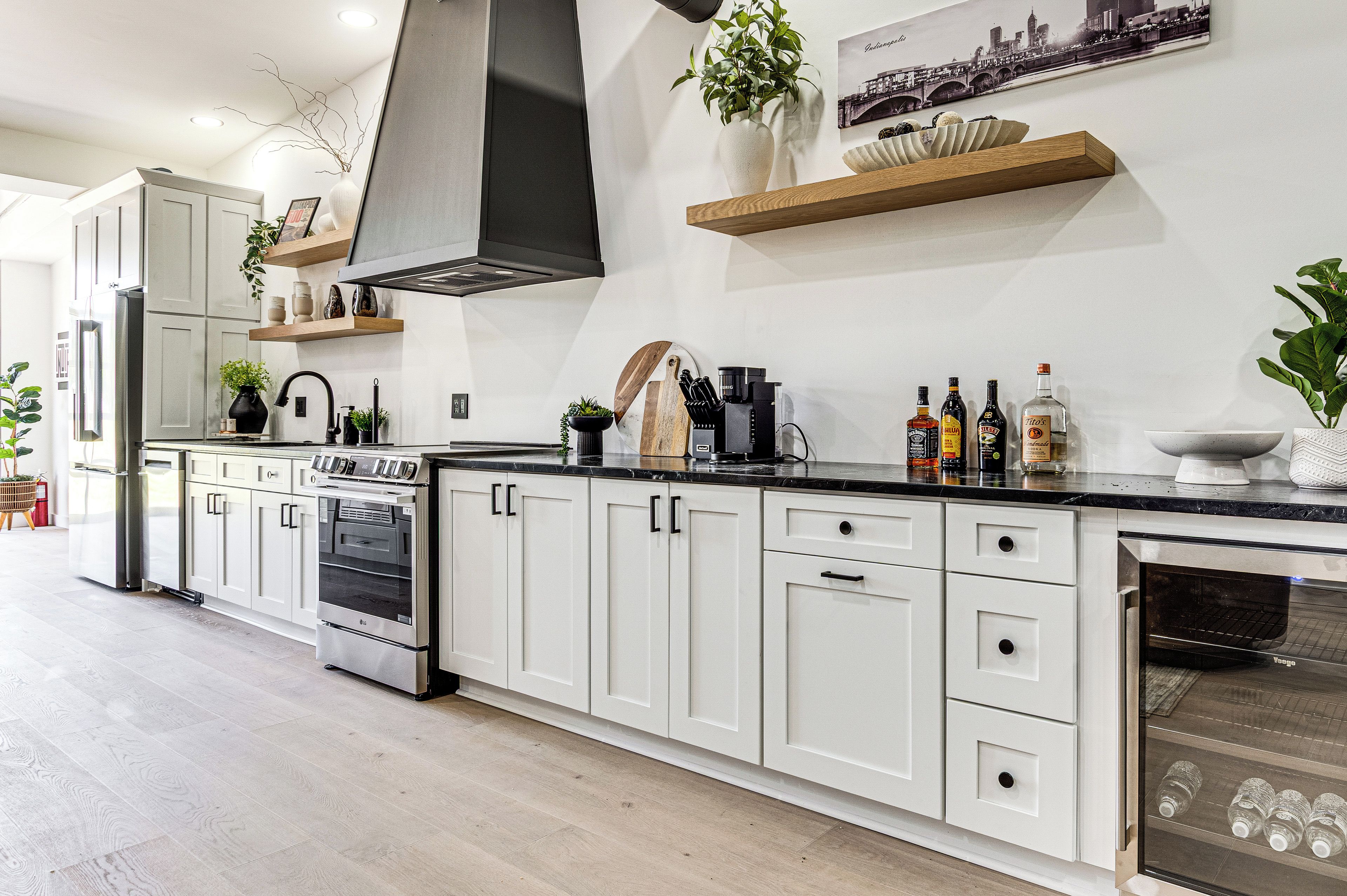 Una cocina moderna con armarios blancos, estufa de acero inoxidable y horno integrado.