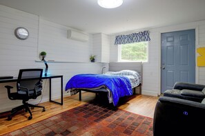 A bedroom with a bed, a desk with a chair, a window, and a door. - Waterfront Escape! Lake Arrowhead Home w/ Fire Pit (Limerick)
