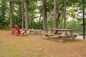 A picnic area with a wooden table and chairs, surrounded by trees and a lake. - Waterfront Escape! Lake Arrowhead Home w/ Fire Pit (Limerick)