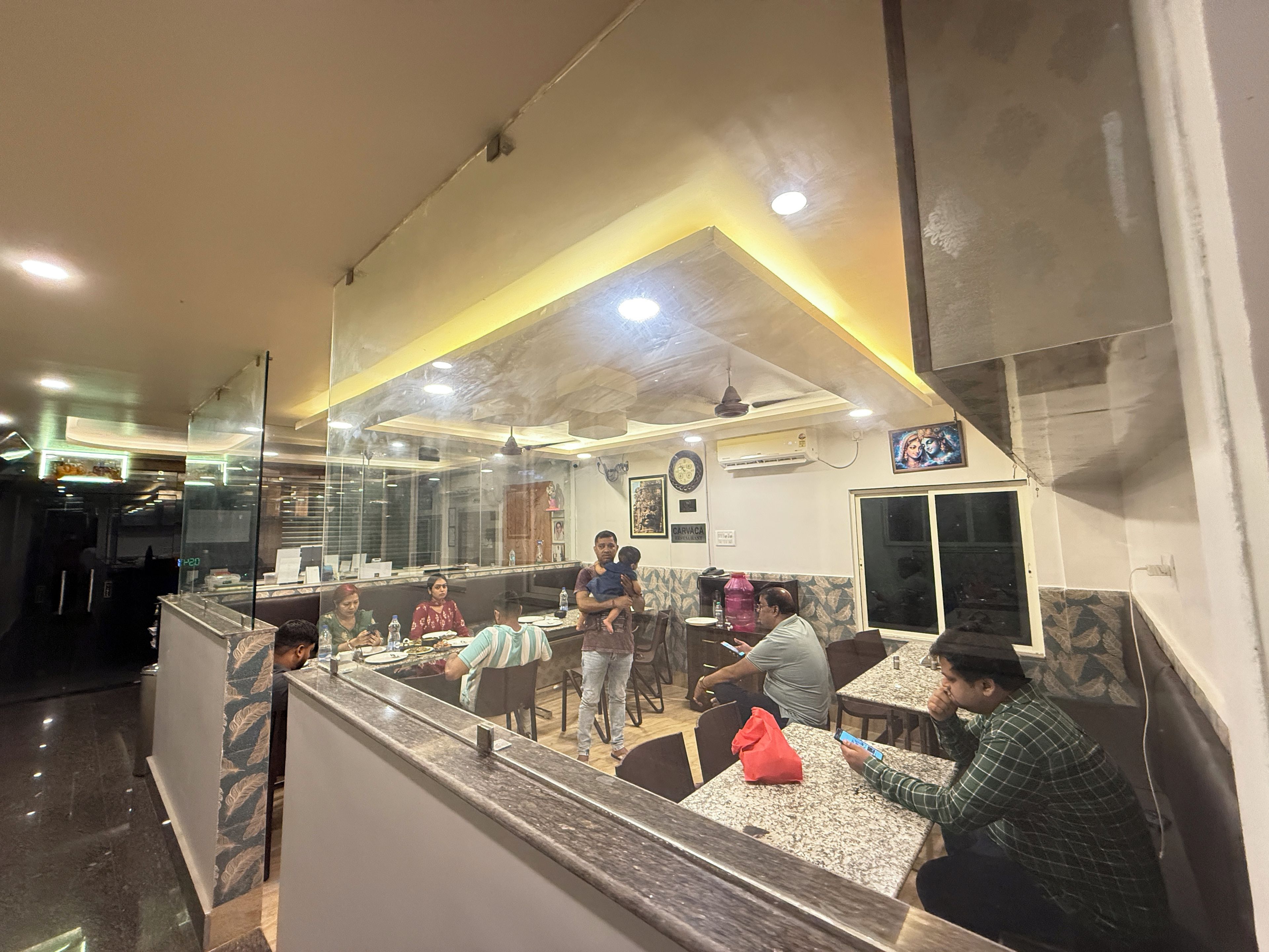 A restaurant interior with a counter, seating area, and a visible menu board.