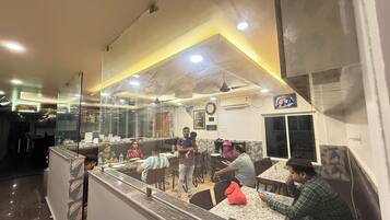 A restaurant interior with a counter, seating area, and a visible menu board.