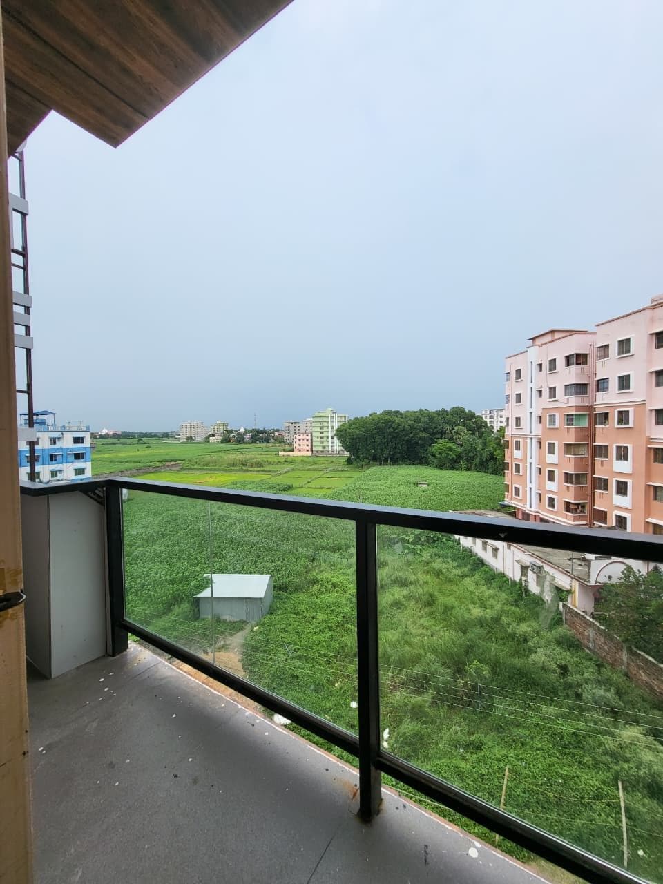 Un balcón con vistas a una zona residencial, con edificios y vegetación.