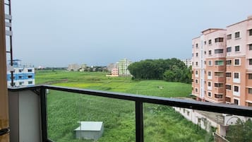 Un balcón con vistas a una zona residencial, con edificios y vegetación.