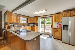 Una cocina moderna con armarios de madera, un refrigerador de acero inoxidable y una isla grande con estufa integrada.