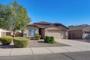 A residential house with a garage, a driveway, and a well-maintained lawn. - 3 Mi to Surprise Stadium! Extended Poolside Stay (Surprise)