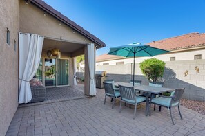 An outdoor patio with a table and chairs, a grill, and a covered area with curtains. - 3 Mi to Surprise Stadium! Extended Poolside Stay (Surprise)