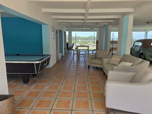 A room with a pool table, a sofa, and a car in the background. - Charming 3-Bedroom House in Monte Vista Fajardo, Puerto Rico (Fajardo city)