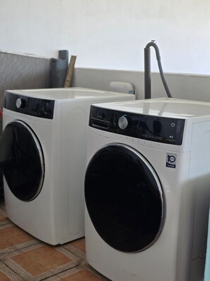 Two front-loading washing machines with a control panel and a power cord. - Charming 3-Bedroom House in Monte Vista Fajardo, Puerto Rico (Fajardo city)