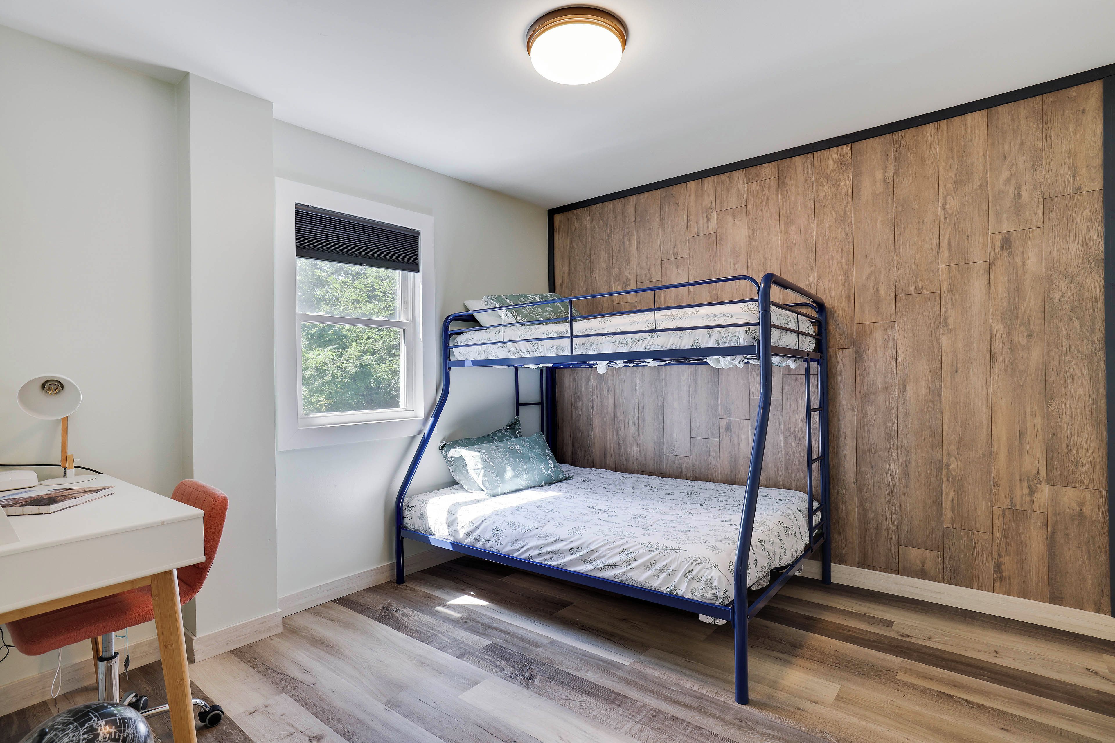 Ein Stockbett mit Holzwand und Fenster.