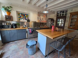 A modern kitchen with a central island, stainless steel appliances, and a variety of decorative items.