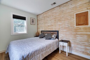 A bedroom with a bed, a nightstand, a wall-mounted shelf, a window, and a door. - Walk to Shops & Dining! Poconos Family Getaway (Tannersville)