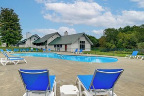 A swimming pool area with lounge chairs and a building with a green roof. - Stowe Ski, Bike & Hike Condo w/ Pools & Clubhouse (Stowe)