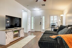 A living room with a television, a sofa, a coffee table, and a fireplace. - Golf Course! Home 12 Mi to Hill Country Wineries (Kyle)