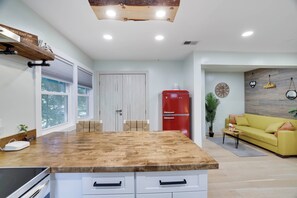A modern kitchen with a central island, a red refrigerator, and a yellow sofa in the living area. - Tannersville Mtn Escape: Ski, Hike & Shop! (Tannersville)