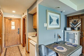 A compact kitchen with a dining area, wooden cabinets, a refrigerator, and a clock. - Glacier Club, Pool Access! San Juan Mountain Condo (Durango)