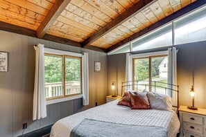 A bedroom with a bed, two bedside lamps, a window with curtains, and a view of greenery outside. - Great for Groups! Wilmington Gem w/ Game Room (Wilmington)