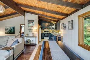 A cozy interior with a wooden ceiling, a kitchen area, and a living space with a sofa and a coffee table. - Great for Groups! Wilmington Gem w/ Game Room (Wilmington)