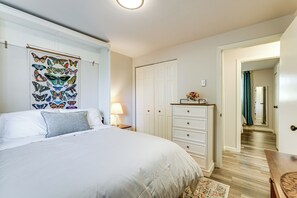 A bedroom with a bed, a nightstand, a dresser, and a wall-mounted butterfly art piece. - 3 Mi to Dtwn & University! Central Eugene Duplex (Eugene)