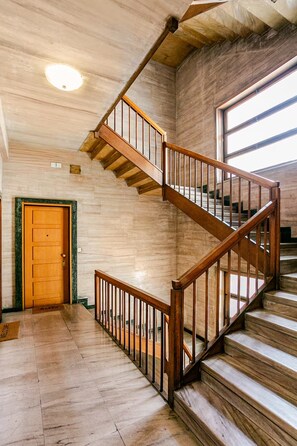 Eine Holztreppe mit Handlauf, die zu einer oberen Etage führt.