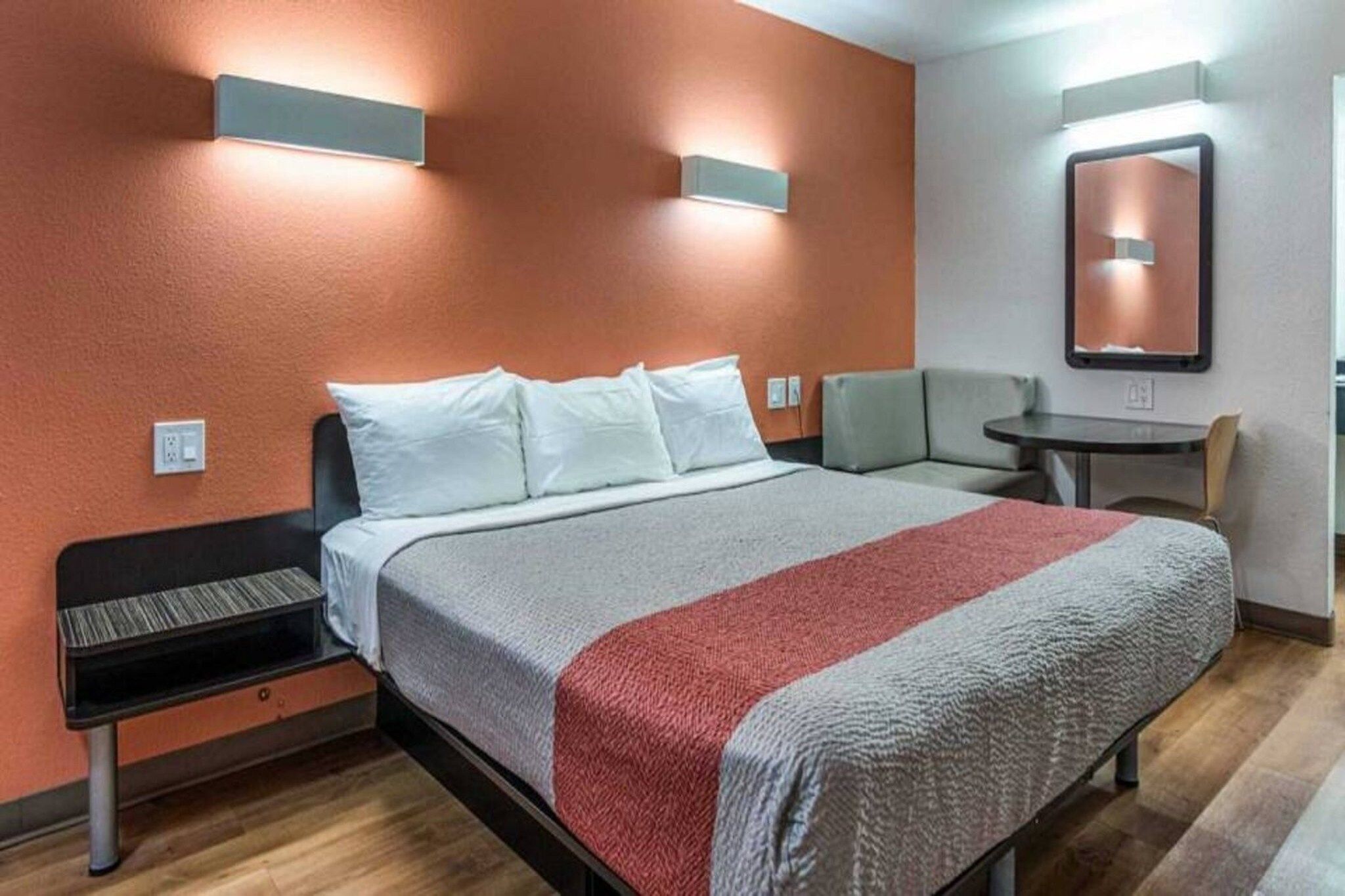 A hotel room with a bed, a desk, and a chair.