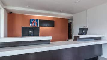 Uma receção com design moderno, um ecrã digital e um letreiro na parede a indicar o número 6.