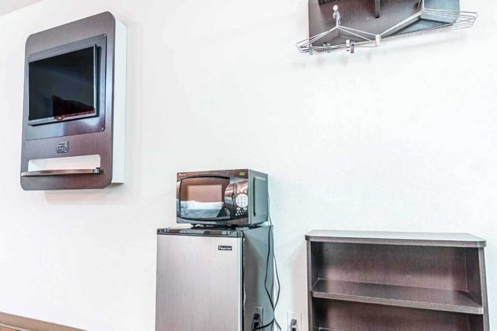 Uma cozinha compacta equipada com micro-ondas, frigorífico e forno pequeno.