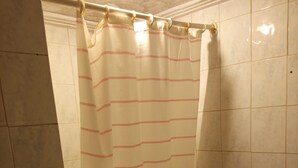 Ein Badezimmer mit Duschvorhang, Toilette und Handtuchhalter.
