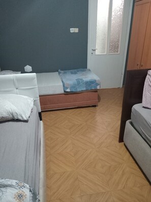 Ein Zimmer mit einem Bett, einem Schlafsofa, einem kleinen Tisch und einem Fenster.
