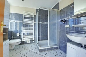 Ein Badezimmer mit Toilette, Dusche und Waschbecken.