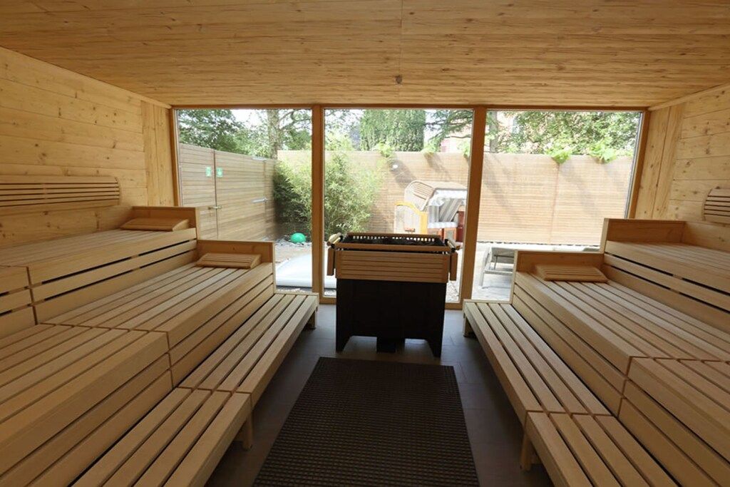 A sauna room with wooden benches and a central table.