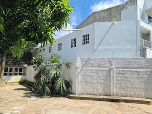 A white building with multiple windows and a brick pathway leading to it. - Casa Mallorca Spacious Family Retreat in Cartagena de Indias (Cartagena)