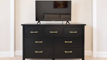 A black dresser with six drawers and a television on top.