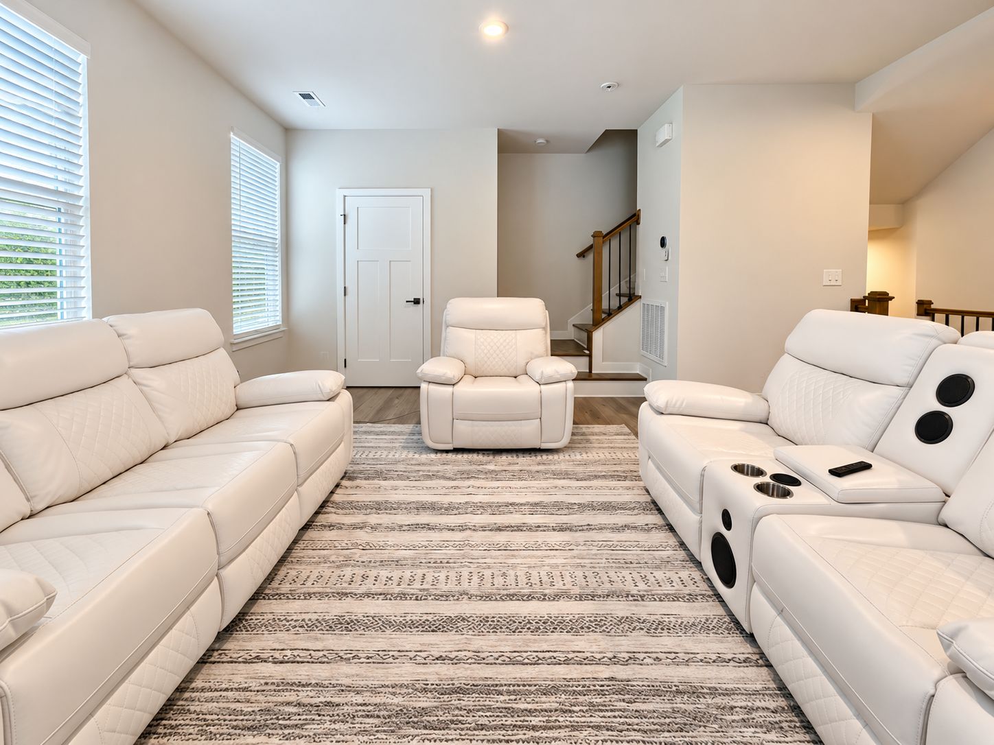 Un salon moderne avec un canapé beige, un fauteuil inclinable et un tapis à motifs.