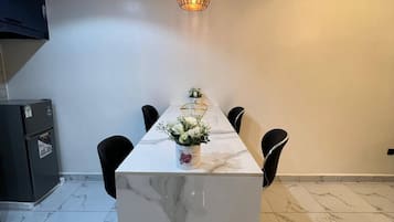 Une cuisine moderne dotée d’un plan de travail en marbre, d’un luminaire suspendu et d’un réfrigérateur.