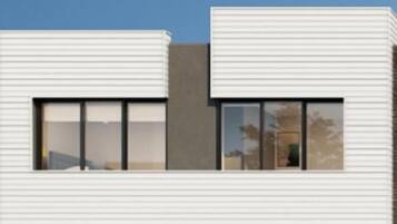 Un bâtiment moderne à deux étages, doté d’un toit plat, de grandes fenêtres et d’une clôture noire à l’avant.