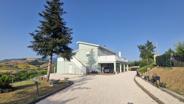 Un bâtiment à deux étages avec une allée menant à un garage.