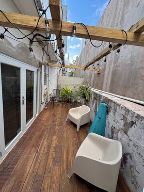 A wooden deck with a built-in seating area, a concrete wall, and a view of the city. - 15 minutes Airport, 10 minutes Old San Juan, private patio and share pool (San Juan city)