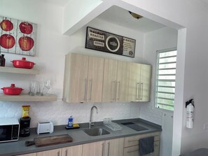 Eine moderne Küche mit Holzschränken, einer Spüle aus Edelstahl und einem Schild mit der Aufschrift Kaffee rösten.