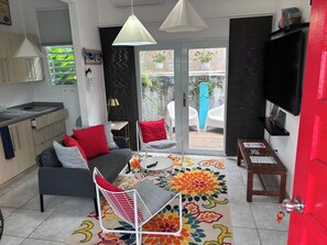 A modern living room with a sofa, chairs, a coffee table, and a TV. - 15 minutes Airport, 10 minutes Old San Juan, private patio and share pool (San Juan city)
