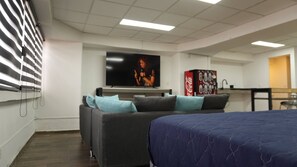 A room with a bed, a sofa, a television, and a vending machine. - Modern Loft King Bed, Wifi & Smart Lock (Mexico City)