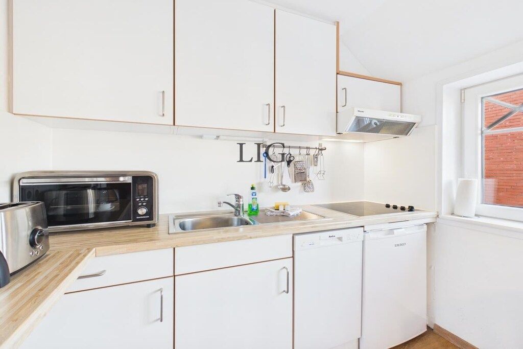 A modern kitchen with white cabinetry, a built-in microwave, a stove, and a dishwasher.