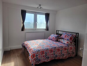 A bedroom with a bed, a window with curtains, a radiator, and a ceiling fan. - Bright and Spacious 2 Bedroom Apartment Nr, Tower and London Bridge (London)