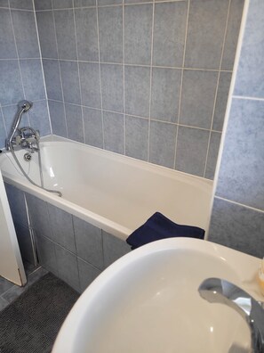 A bathroom with a bathtub, a sink, and tiled walls. - Bright and Spacious 2 Bedroom Apartment Nr, Tower and London Bridge (London)