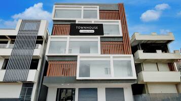 A multi-story building with a sign reading 'TOWNHOUSE Company-Serviced'.