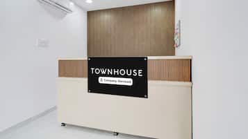 A reception desk with a sign that reads 'TOWNHOUSE Company-Serviced.'