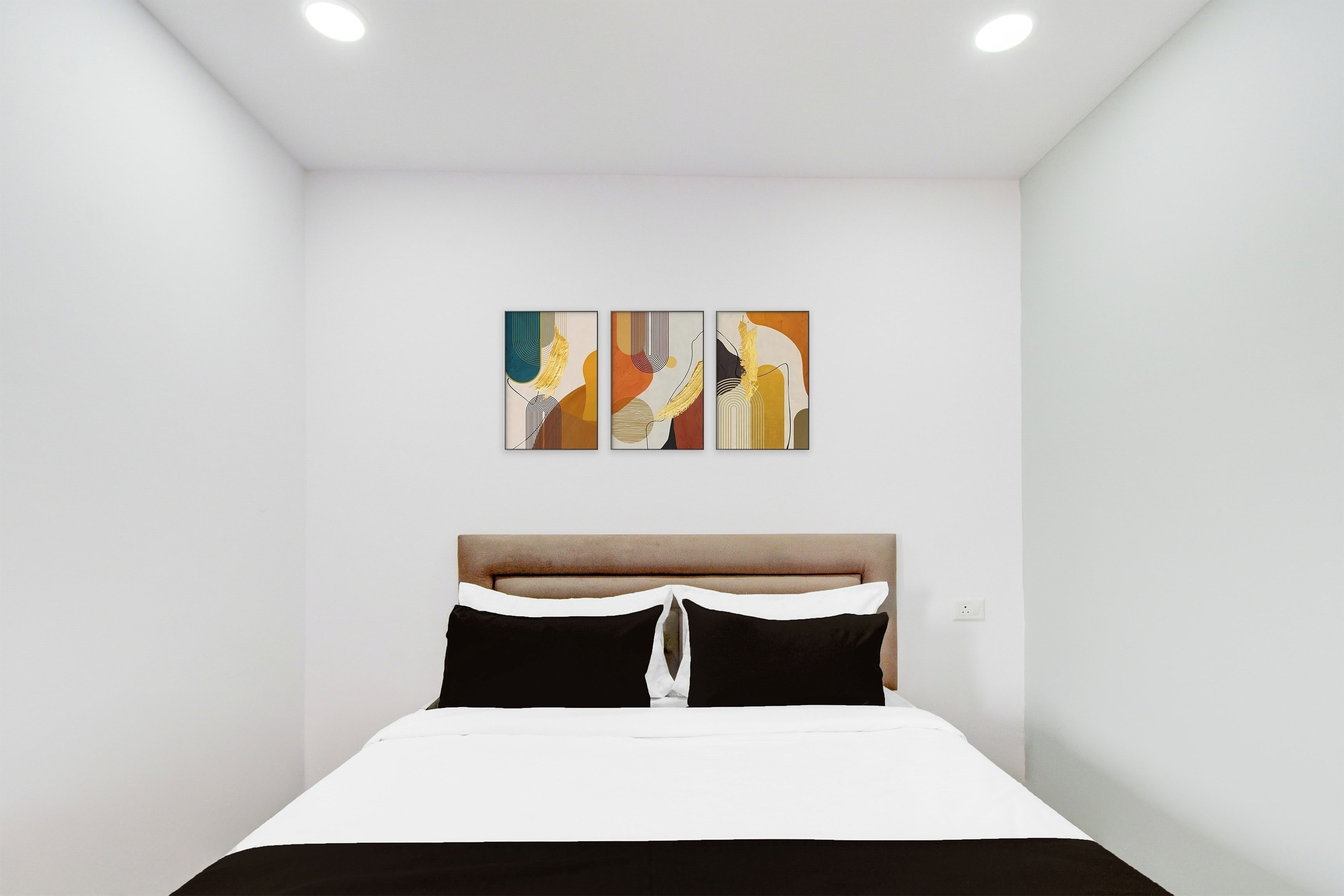 A bedroom with a bed, a headboard, and three abstract paintings on the wall.