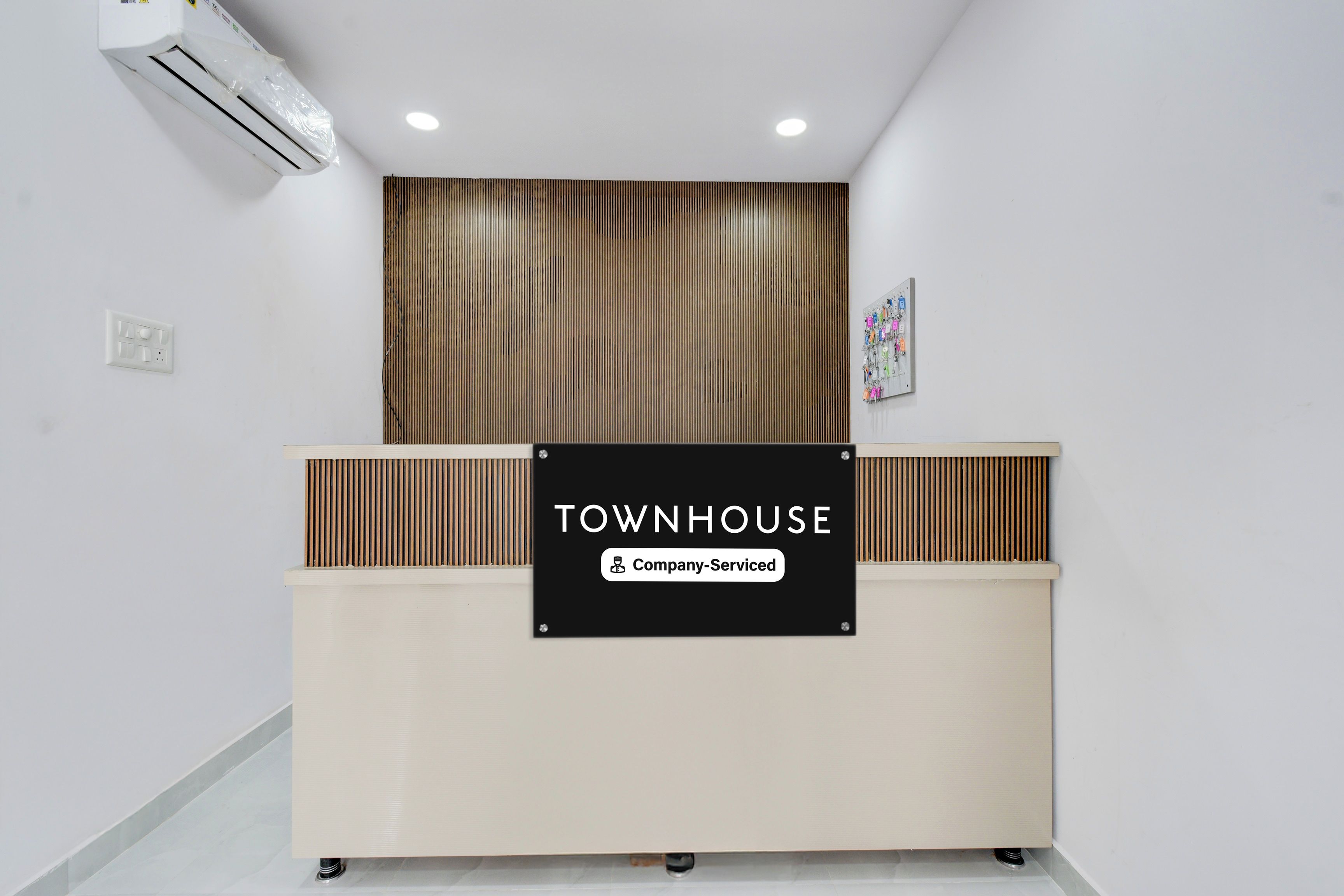Una mesa de recepción con un cartel que dice 'TOWNHOUSE Company-Serviced'.