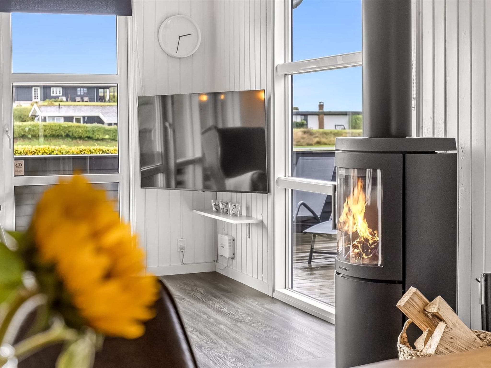 Una sala moderna con chimenea, televisión y vistas al exterior.