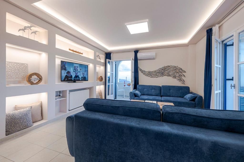 Una sala de estar moderna con un sofá azul, un televisor de pantalla plana y estanterías empotradas con objetos decorativos.